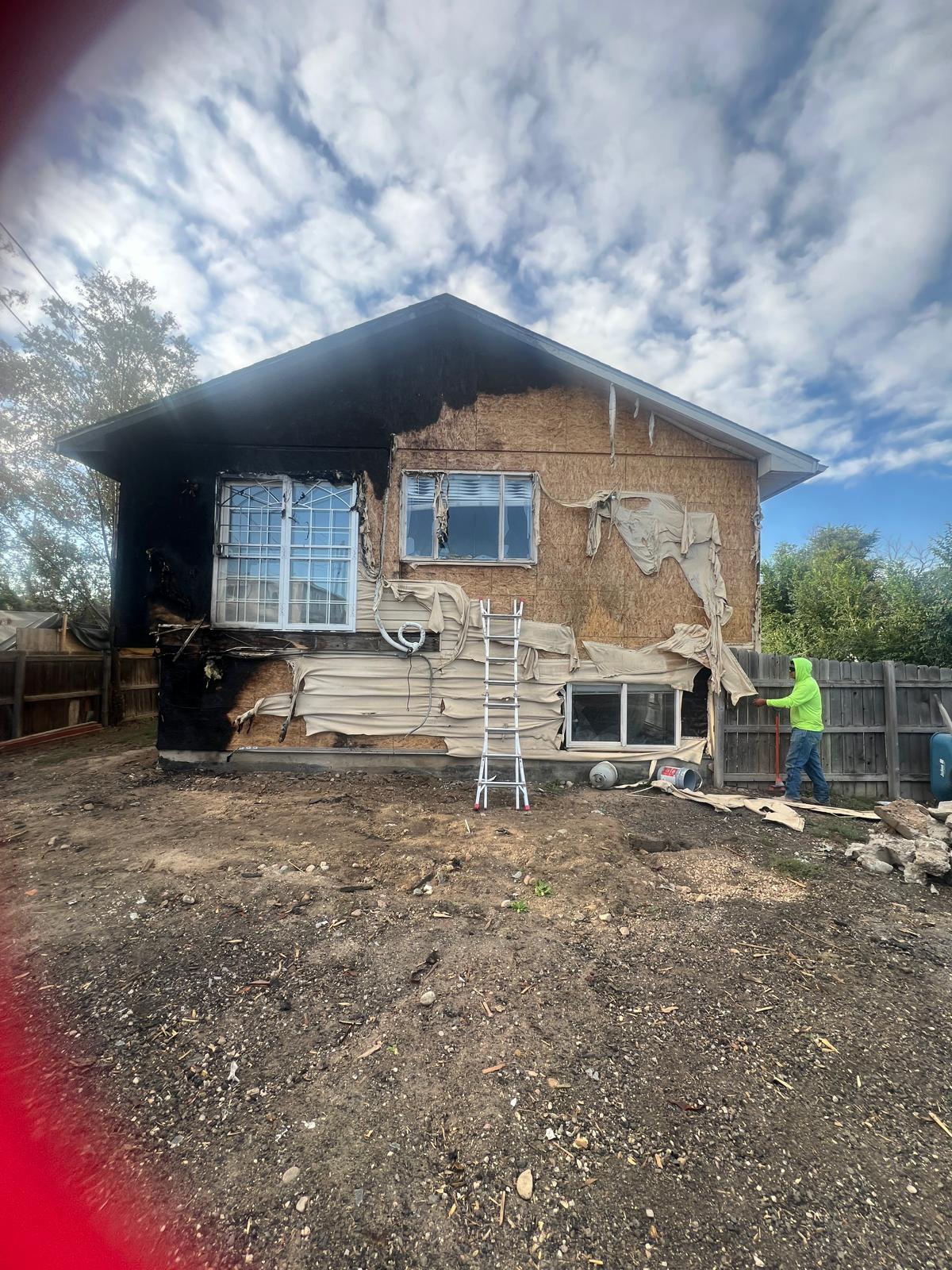 Fire-damaged home exterior before restoration — Force Construction Inc.