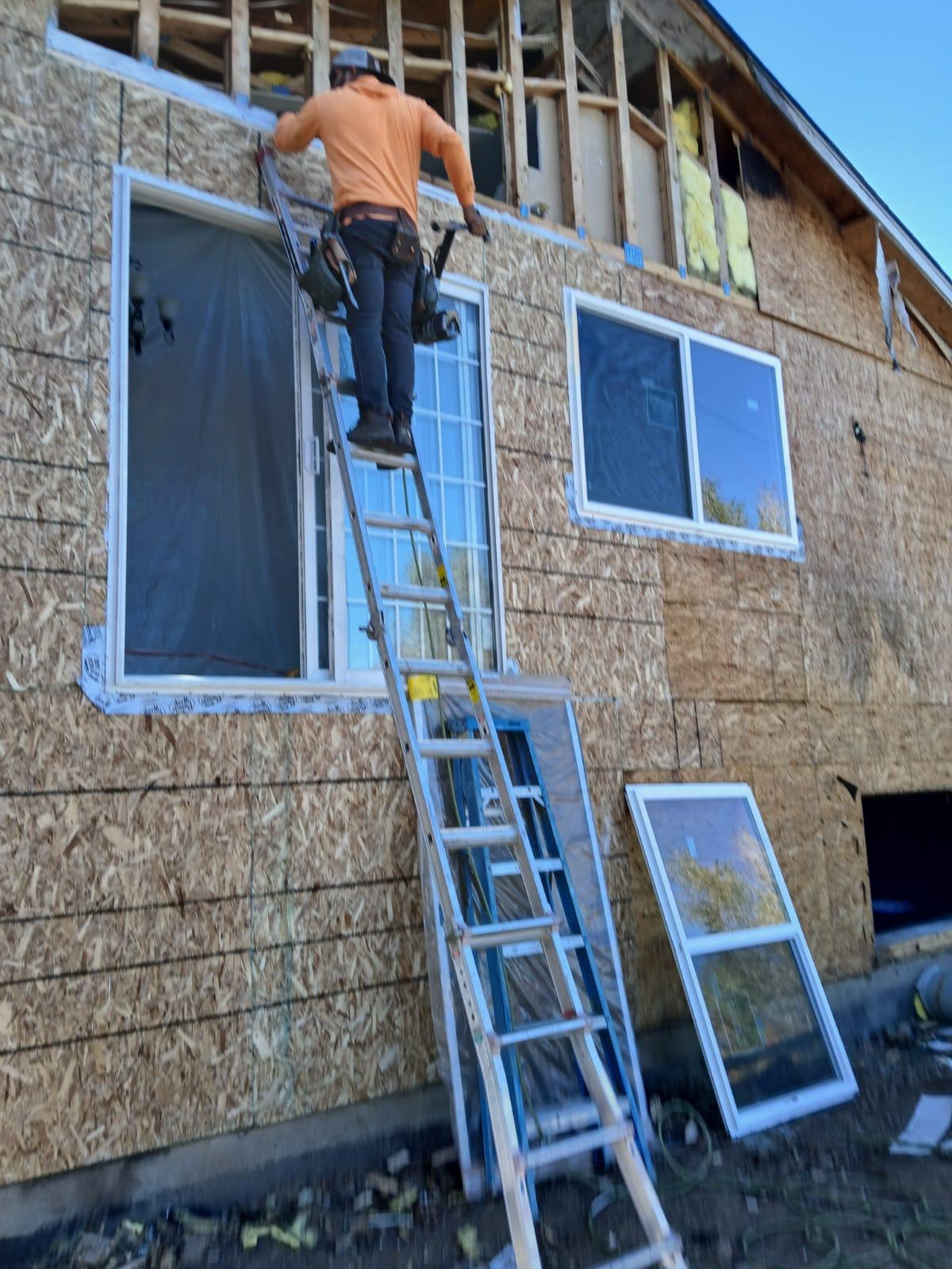 Worker on ladder during exterior restoration — Force Construction Inc.